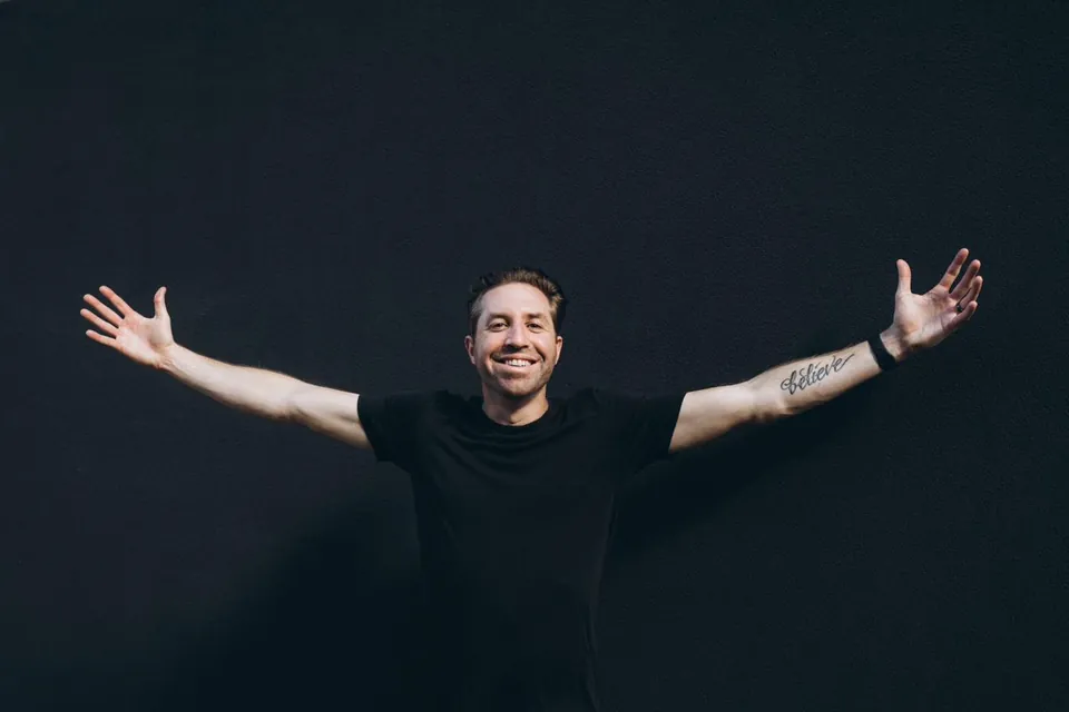 Rob Cressy, human-first AI coach, smiling with his arms wide open