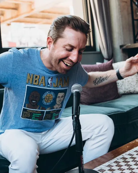 Rob Cressy laughing behind a microphone during a podcast recording
